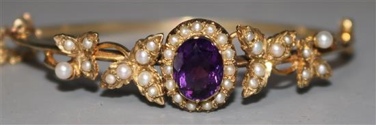 An Edwardian cased gold, amethyst and seed pearl set hinged bangle.